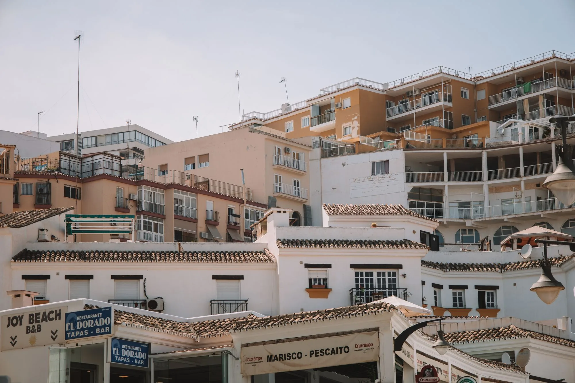Balcones clásicos de edificios residenciales bajo un cielo azul en Málaga, España