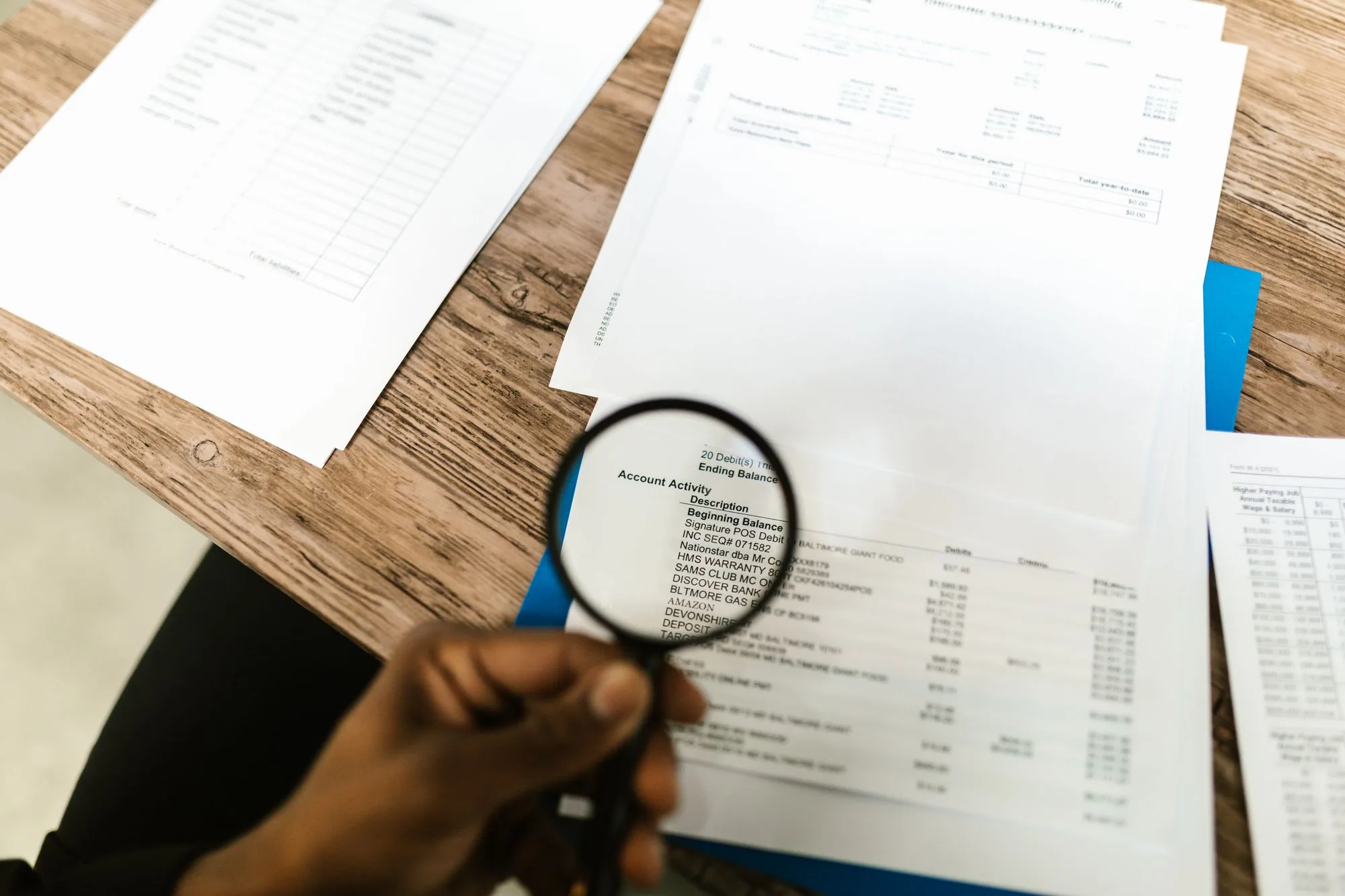 Persona revisando documentos con una lupa